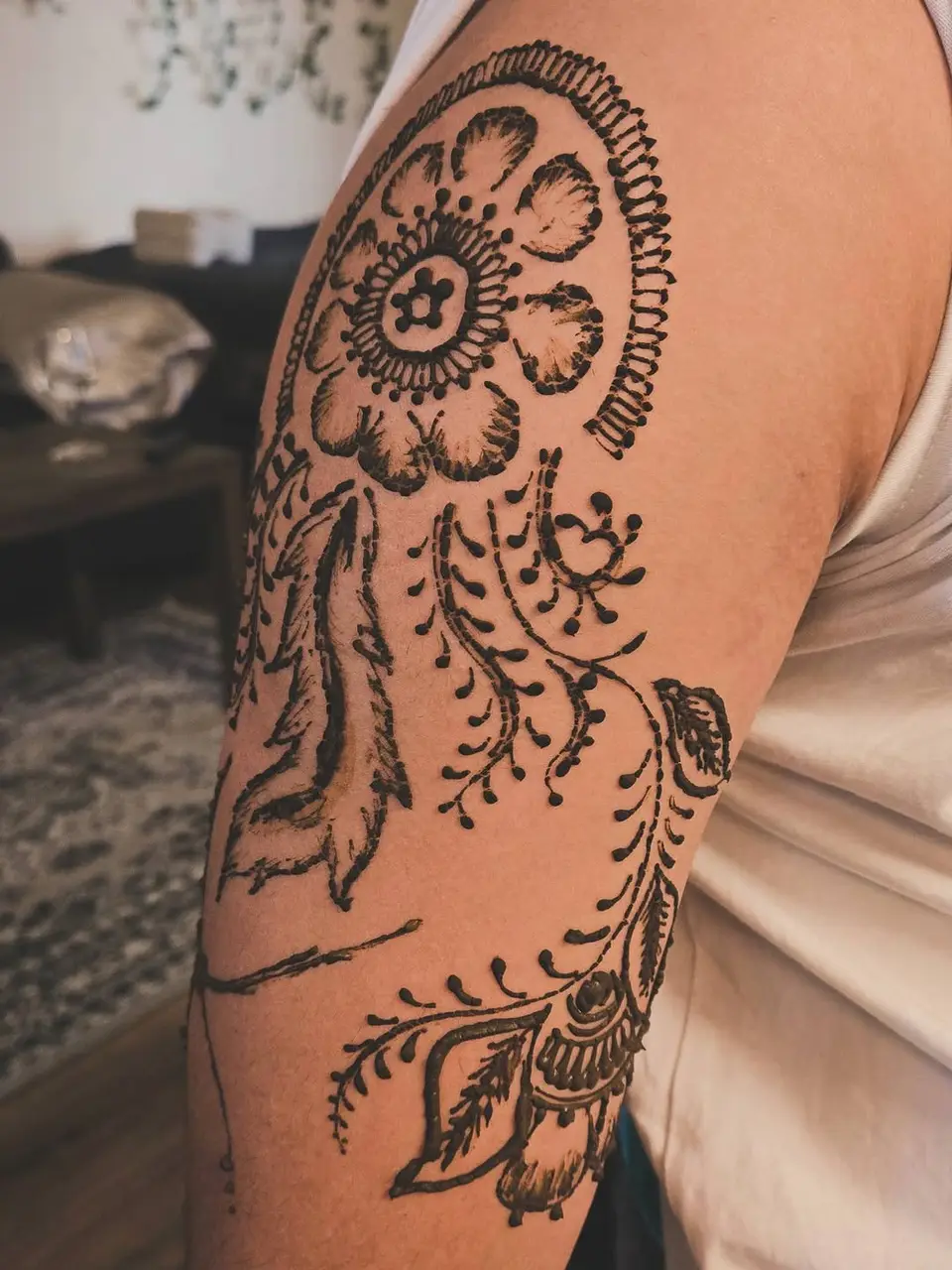 A large flower and a hanging vine drawn on the upper arm