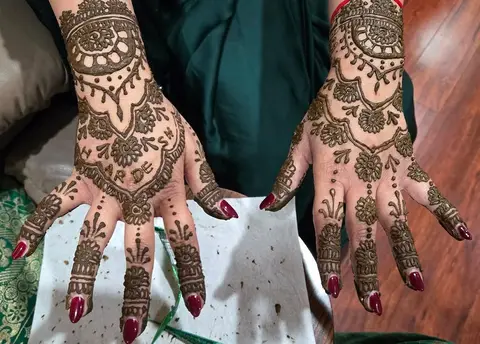 The backs of two hands with full traditional henna from wrist to fingertip